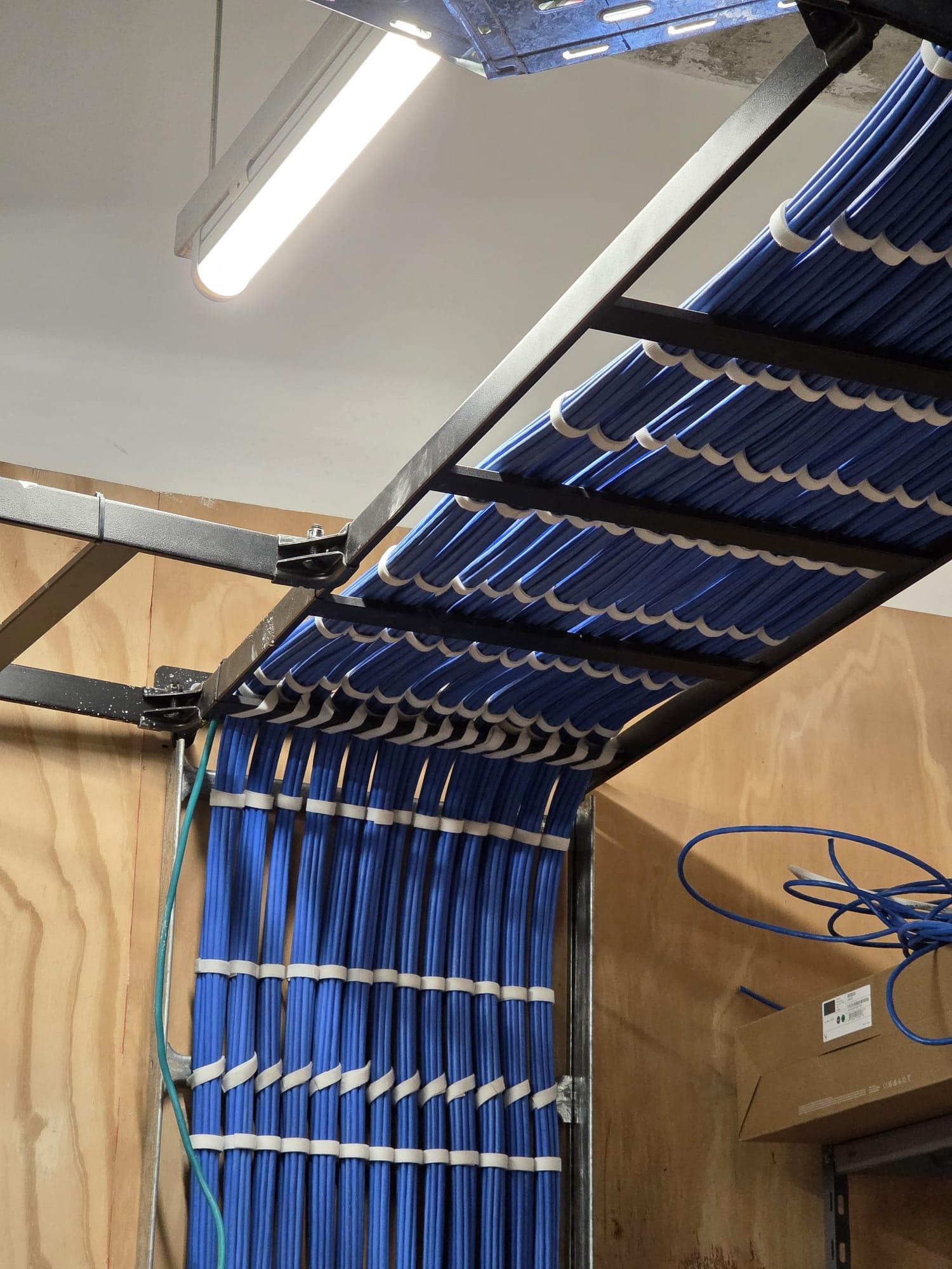 Vertical drop to the rack. A clean waterfall from the ladder rack into the telecom room.